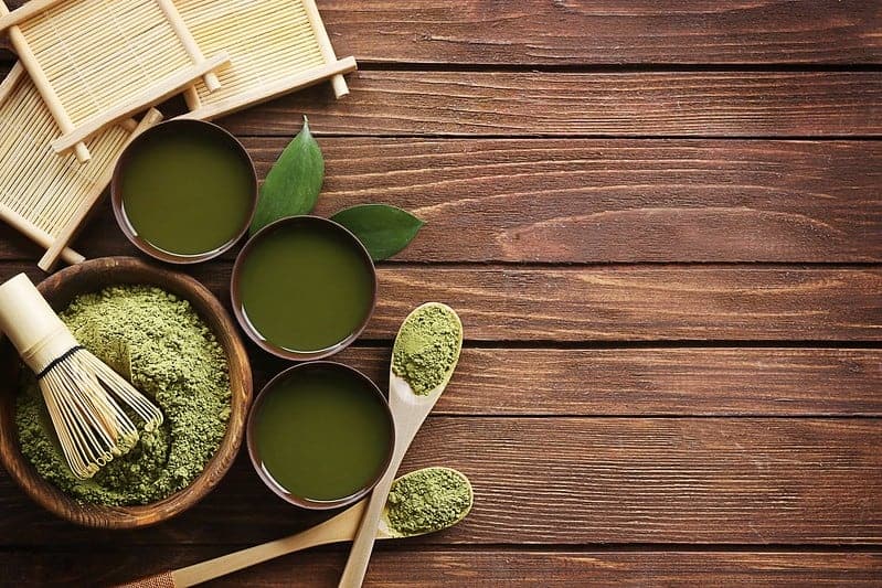 grüner Matcha-Teepulver in Salat- und Flüssigkeitstassen
