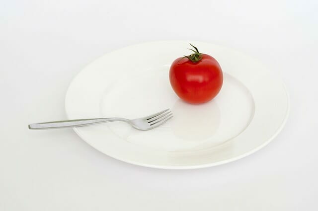  Eine Tomate und eine Gabel auf deinem Teller