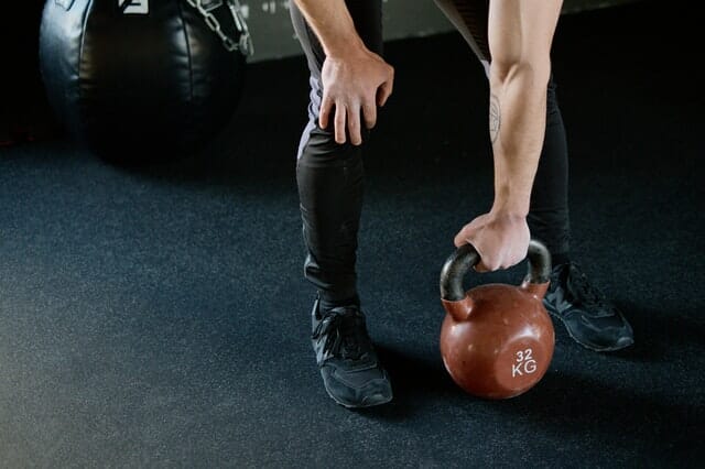  Ein Mann trainiert mit Gewichten im Fitnessstudio