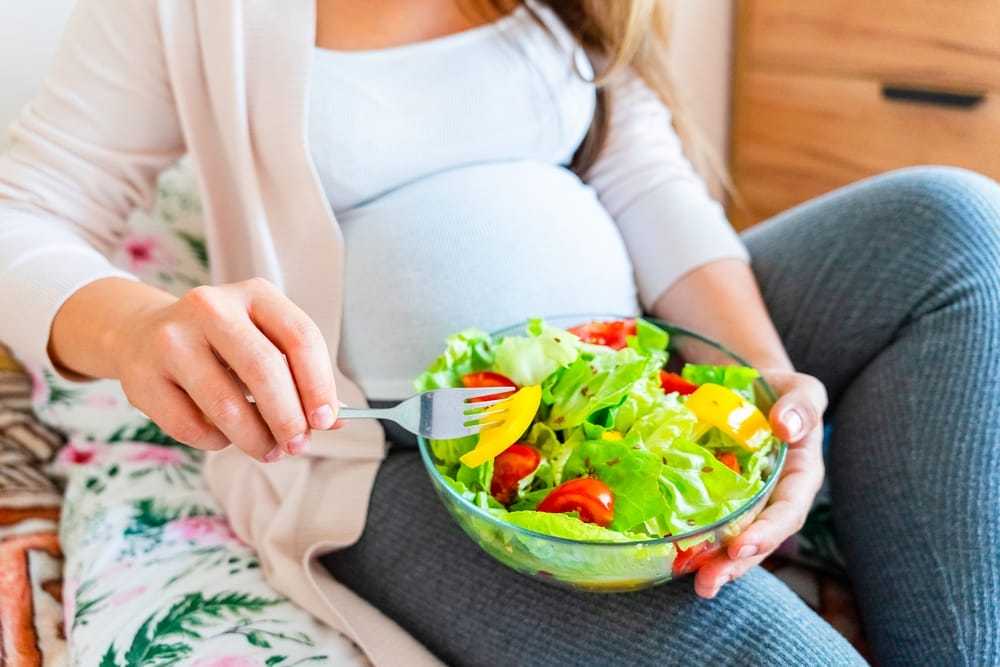  Schwangere Frau isst Salat